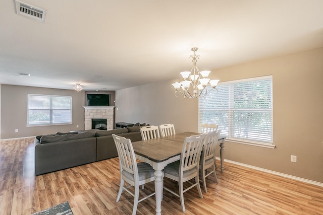 2153 Valley Forge Trl, Fort Worth, TX 76177 - dining space featuring light wood finished floors, a stone fireplace, and a chandelier