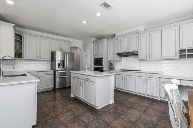 3912 Appleton Ln, Flower Mound, TX 75022 - kitchen featuring black appliances, recessed lighting, tasteful backsplash, under cabinet range hood, and arched walkways