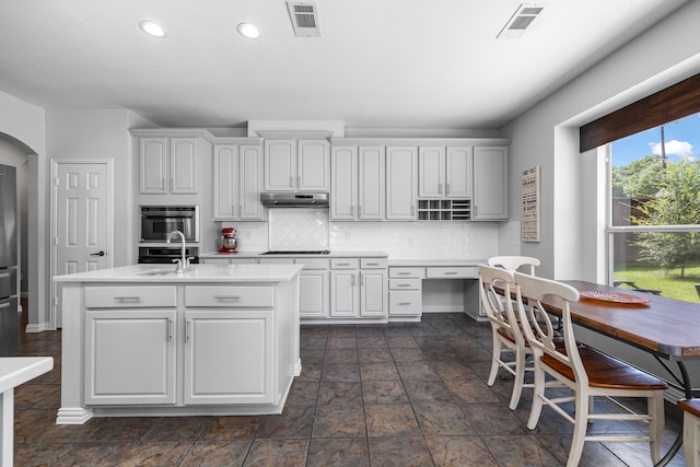 3912 Appleton Ln, Flower Mound, TX 75022 - kitchen featuring light countertops, recessed lighting, under cabinet range hood, decorative backsplash, and a center island with sink