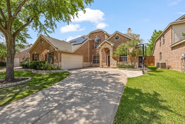 3912 Appleton Ln, Flower Mound, TX 75022 - traditional-style house featuring a garage, concrete driveway, a chimney, roof mounted solar panels, and brick siding