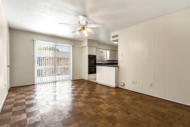 5835 E University Blvd Unit D, Dallas, TX 75206 - unfurnished living room featuring a ceiling fan and baseboards