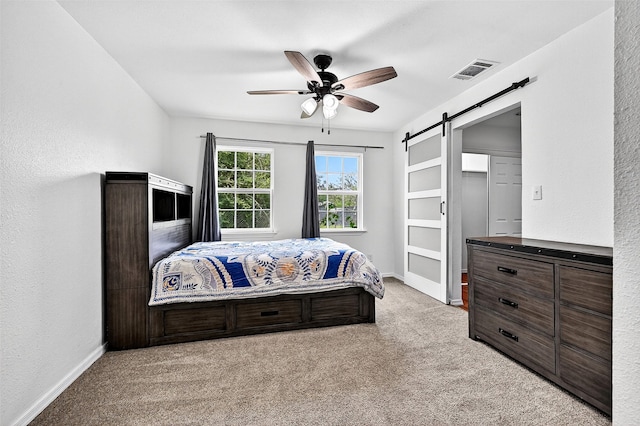 231 Juniper Dr, Pottsboro, TX 75076 - bedroom with light carpet, a barn door, a ceiling fan, and a textured wall