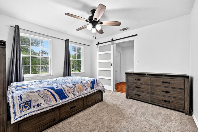231 Juniper Dr, Pottsboro, TX 75076 - carpeted bedroom featuring a barn door and ceiling fan