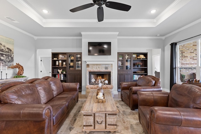 301 Aviara Ct, Poolville, TX 76487 - living room featuring a tray ceiling, a stone fireplace, ceiling fan, crown molding, and light wood-type flooring