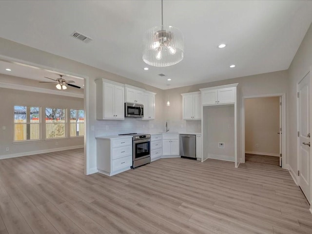 108 Saddle Brook Dr, Lufkin, TX 75904 - kitchen featuring stainless steel appliances, open floor plan, light wood-style floors, tasteful backsplash, and recessed lighting