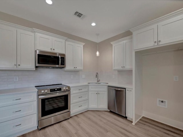 108 Saddle Brook Dr, Lufkin, TX 75904 - kitchen with stainless steel appliances, white cabinetry, light countertops, decorative backsplash, and recessed lighting