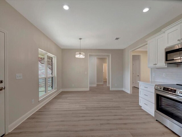 108 Saddle Brook Dr, Lufkin, TX 75904 - kitchen with stainless steel appliances, white cabinets, light wood-style floors, recessed lighting, and tasteful backsplash