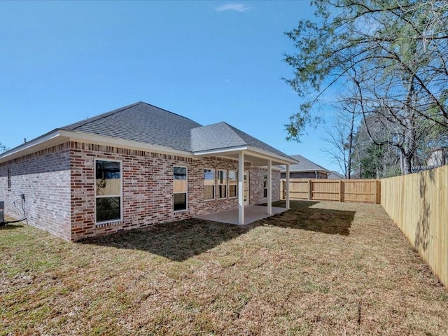 108 Saddle Brook Dr, Lufkin, TX 75904 - back of property featuring a shingled roof, brick siding, a fenced backyard, and a patio