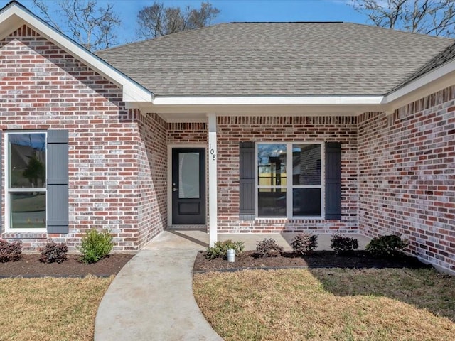 108 Saddle Brook Dr, Lufkin, TX 75904 - view of exterior entry with brick siding, roof with shingles, and a lawn