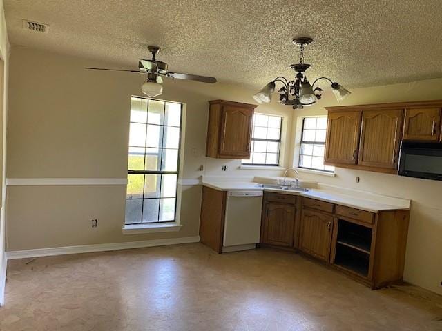 126 Oak St, Lancaster, TX 75146 - kitchen with white dishwasher, black microwave, a textured ceiling, a chandelier, and brown cabinetry