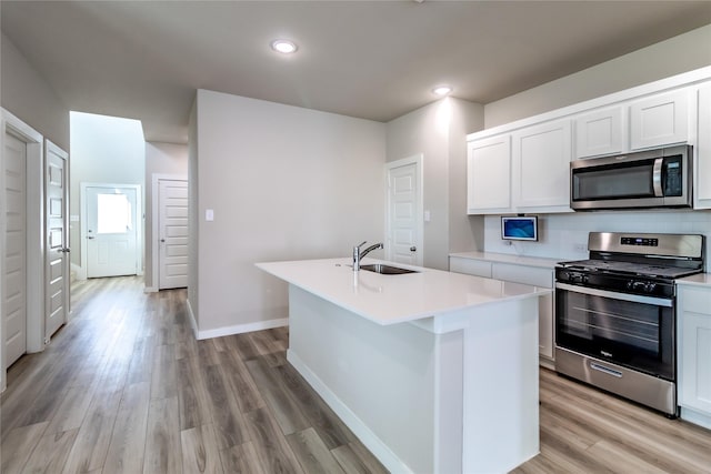 2208 Wexford Way, Forney, TX 75126 - kitchen with stainless steel appliances, a center island with sink, light countertops, light wood finished floors, and white cabinetry