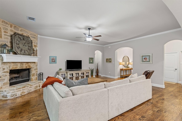 301 Prairie Oak Ct, Burleson, TX 76028 - living area with a ceiling fan, arched walkways, dark wood-type flooring, ornamental molding, and a stone fireplace