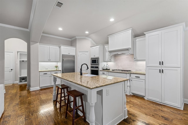 301 Prairie Oak Ct, Burleson, TX 76028 - kitchen with built in appliances, backsplash, crown molding, a breakfast bar, and white cabinets