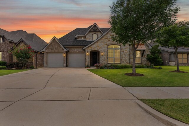 301 Prairie Oak Ct, Burleson, TX 76028 - french country home with stone siding, an attached garage, concrete driveway, a yard, and a shingled roof