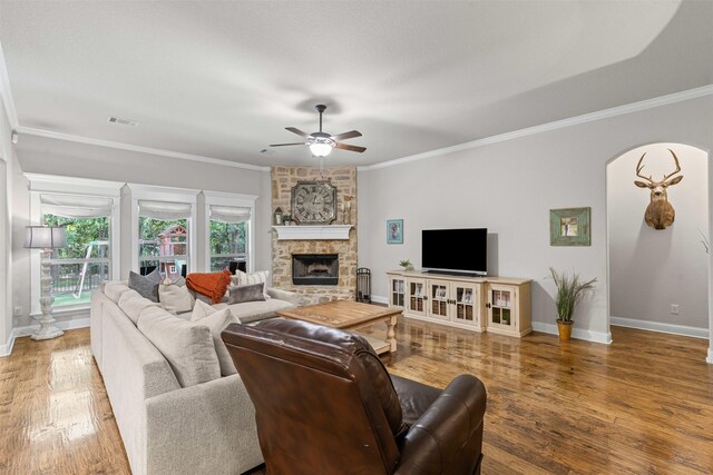 301 Prairie Oak Ct, Burleson, TX 76028 - living area with a ceiling fan, a fireplace, wood finished floors, ornamental molding, and arched walkways