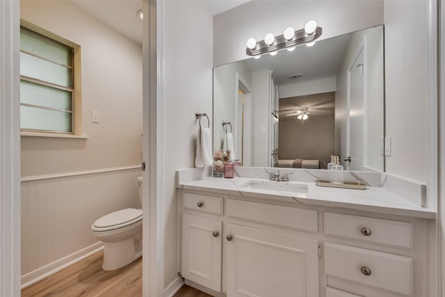 5504 Whitman Ave, Fort Worth, TX 76133 - bathroom with vanity, wood finished floors, ceiling fan, wainscoting, and ensuite bathroom