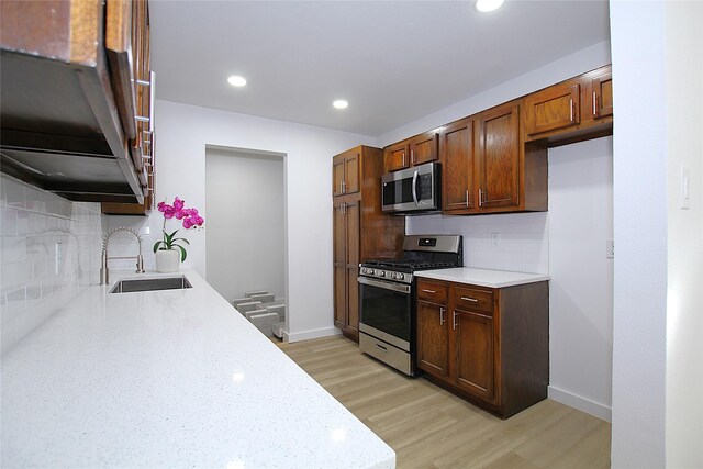 1825 Grove Cir, Mesquite, TX 75149 - kitchen featuring appliances with stainless steel finishes, backsplash, light wood-style flooring, recessed lighting, and light stone countertops
