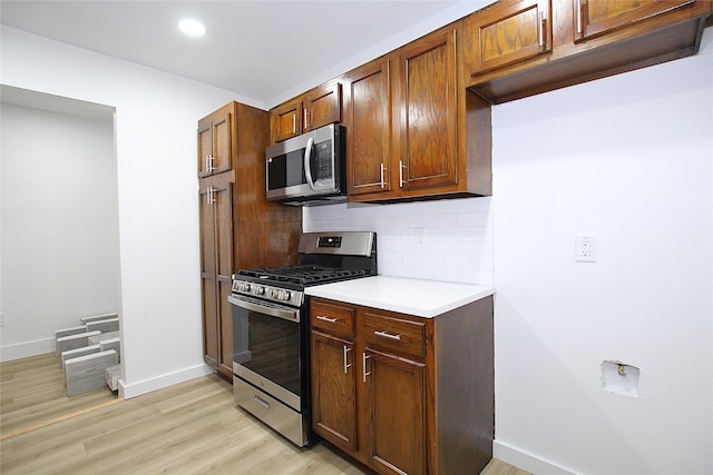 1825 Grove Cir, Mesquite, TX 75149 - kitchen featuring stainless steel appliances, backsplash, light wood-type flooring, light countertops, and brown cabinets