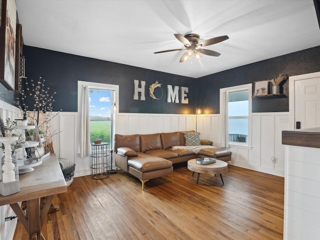 309 E 3rd St, Maypearl, TX 76064 - living room featuring wainscoting, ceiling fan, hardwood / wood-style flooring, and a decorative wall