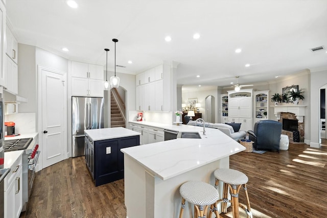 6617 Whittier Ln, Colleyville, TX 76034 - kitchen with premium appliances, open floor plan, a fireplace, a kitchen island, and dark wood-type flooring