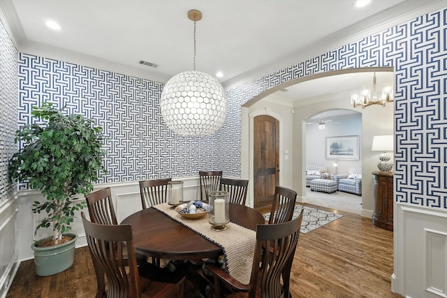 6617 Whittier Ln, Colleyville, TX 76034 - dining room featuring wallpapered walls, arched walkways, wood finished floors, crown molding, and recessed lighting