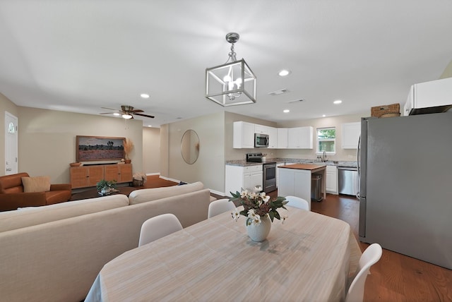 3767 Matson St, North Richland Hills, TX 76117 - dining area featuring dark wood finished floors, a ceiling fan, recessed lighting, and a chandelier