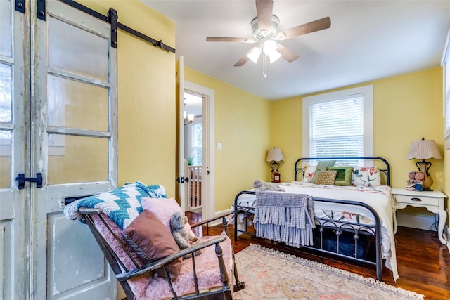 2324 Lynnhaven Rd, Fort Worth, TX 76103 - bedroom featuring wood finished floors, a ceiling fan, and a barn door