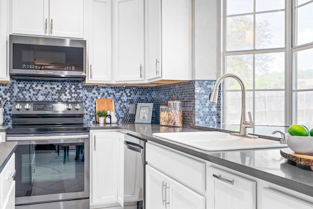 1092 Rosewood Dr, Grapevine, TX 76051 - kitchen with stainless steel appliances, white cabinets, decorative backsplash, and dark countertops