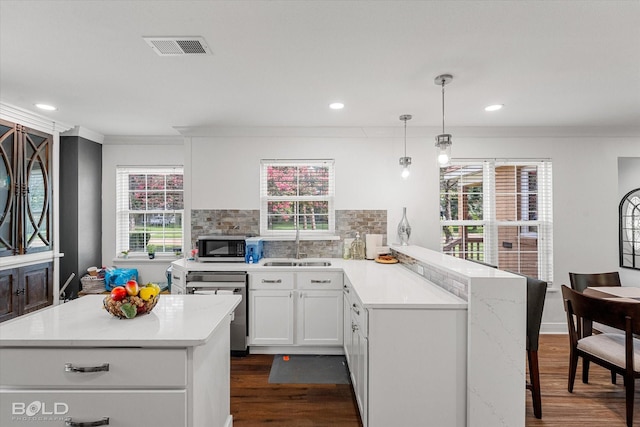 107 Preston Ave, Shreveport, LA 71105 - kitchen featuring appliances with stainless steel finishes, dark wood-type flooring, a peninsula, ornamental molding, and decorative backsplash