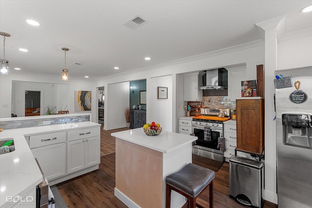 107 Preston Ave, Shreveport, LA 71105 - kitchen with stainless steel appliances, wall chimney exhaust hood, crown molding, a kitchen island, and dark wood-style floors