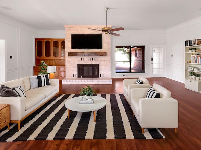 1846 Green Tree Ln, Duncanville, TX 75137 - living room featuring a decorative wall, a ceiling fan, wood finished floors, a fireplace, and crown molding