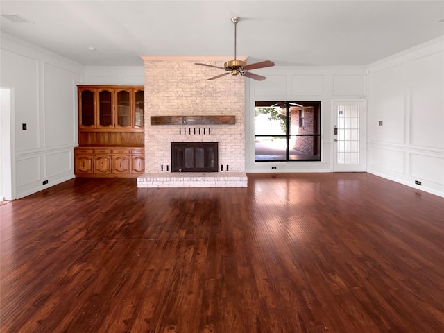 1846 Green Tree Ln, Duncanville, TX 75137 - unfurnished living room with a decorative wall, wood finished floors, ceiling fan, a brick fireplace, and ornamental molding
