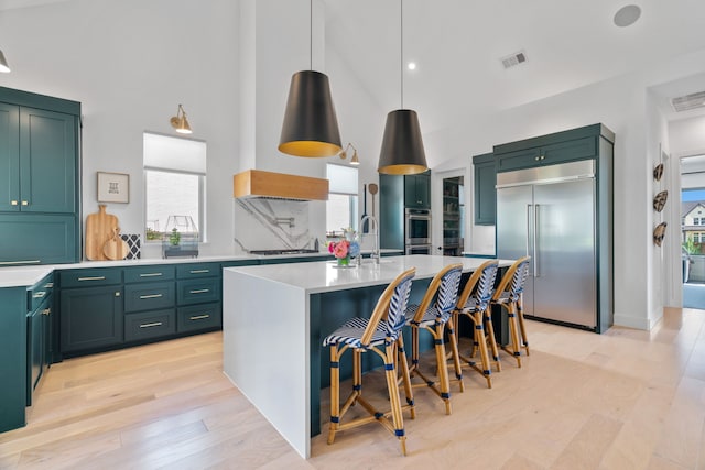 403 Trigger Trl, Argyle, TX 76226 - kitchen with appliances with stainless steel finishes, high vaulted ceiling, light countertops, an island with sink, and light wood-style flooring