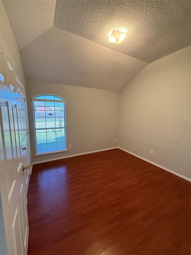 1401 Williams Crk, Mesquite, TX 75181 - empty room with lofted ceiling, dark wood-type flooring, and a textured ceiling