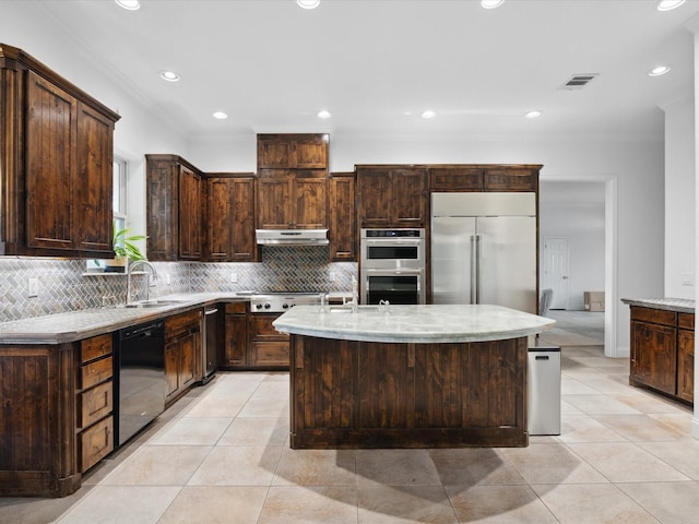 186 Deer Creek Dr, Aledo, TX 76008 - kitchen featuring stainless steel appliances, ornamental molding, dark brown cabinets, decorative backsplash, and an island with sink