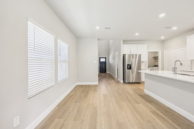 505 Willet Dr, Mckinney, TX 75069 - kitchen featuring stainless steel refrigerator with ice dispenser, light countertops, light wood-style flooring, white cabinets, and recessed lighting