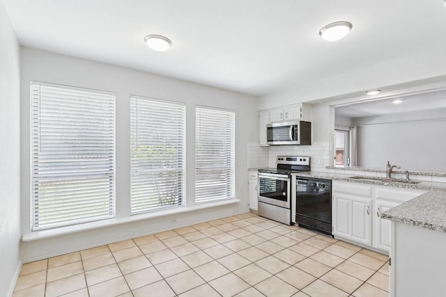 1109 Paluxy Ct, Flower Mound, TX 75028 - kitchen with appliances with stainless steel finishes, white cabinetry, decorative backsplash, and light tile patterned floors