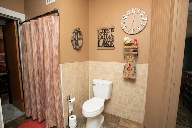 10234 County Road 198, Breckenridge, TX 76424 - bathroom with tile walls, a wainscoted wall, and curtained shower