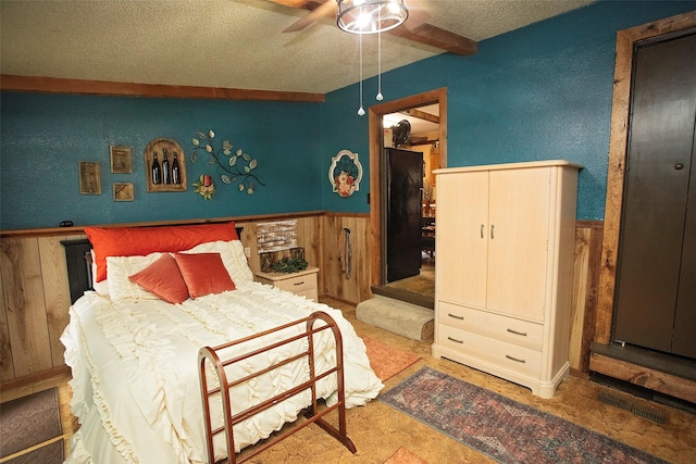10234 County Road 198, Breckenridge, TX 76424 - bedroom featuring a textured ceiling, a wainscoted wall, wood walls, a ceiling fan, and a textured wall