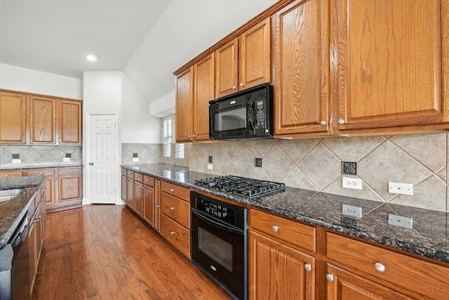 8120 Tyler Dr, Lantana, TX 76226 - kitchen with black appliances, dark wood-type flooring, brown cabinetry, and dark stone countertops