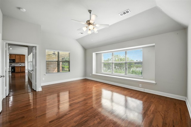 8120 Tyler Dr, Lantana, TX 76226 - unfurnished bedroom featuring vaulted ceiling, multiple windows, dark wood-style floors, and ceiling fan