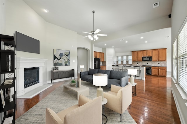 8120 Tyler Dr, Lantana, TX 76226 - living area with a high ceiling, dark wood-style floors, a glass covered fireplace, healthy amount of natural light, and recessed lighting
