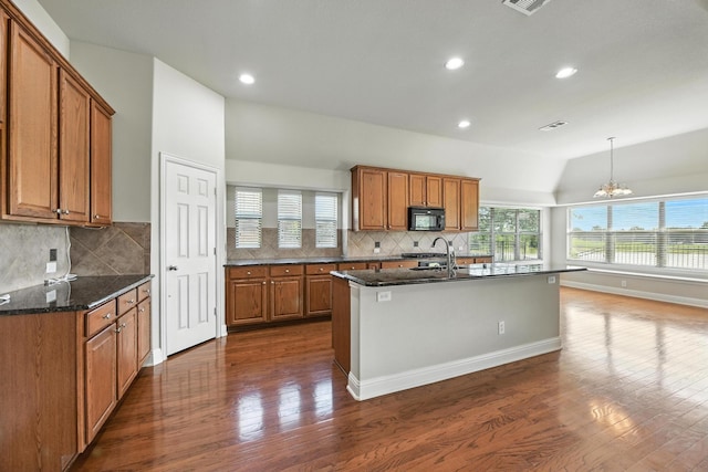 8120 Tyler Dr, Lantana, TX 76226 - kitchen featuring black microwave, brown cabinetry, dark wood finished floors, lofted ceiling, and tasteful backsplash