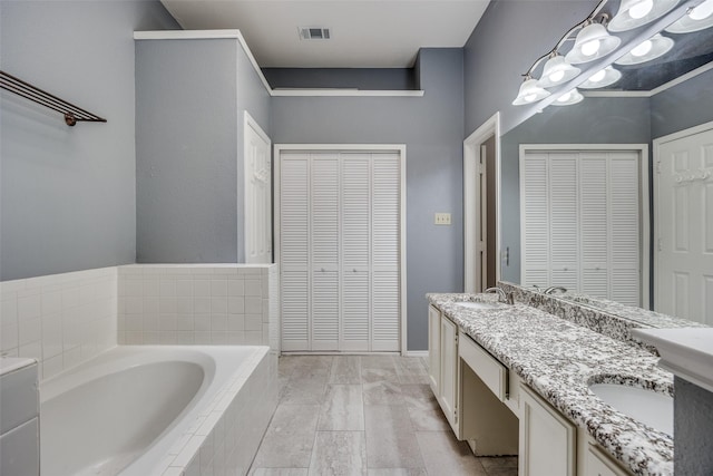 2102 Overview Ln, Garland, TX 75044 - bathroom featuring a closet, a bath, and double vanity