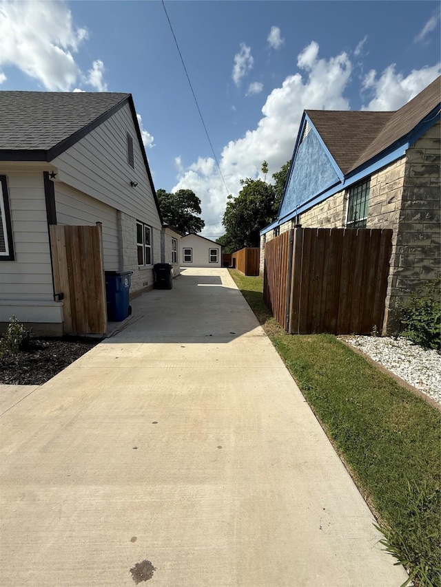 1019 E Waco Ave, Dallas, TX 75216 - view of home's exterior featuring concrete driveway and a shingled roof