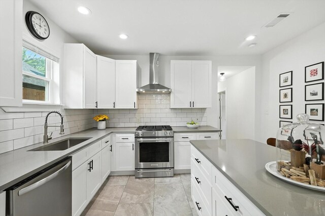 1415 W St, Mckinney, TX 75069 - kitchen featuring appliances with stainless steel finishes, wall chimney range hood, backsplash, white cabinetry, and recessed lighting