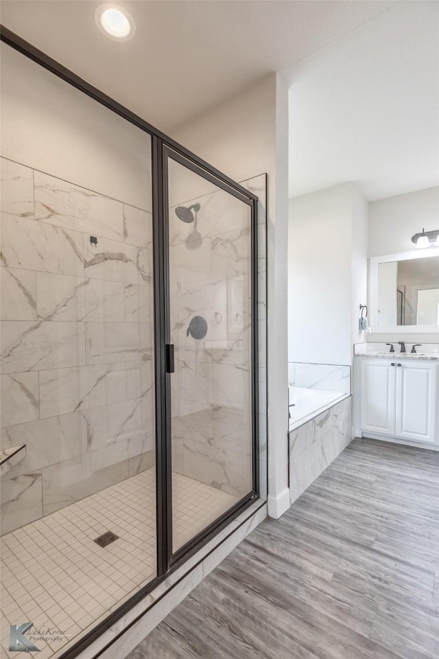 7309 Wildflower Way, Abilene, TX 79602 - full bathroom with a stall shower, a garden tub, vanity, wood finished floors, and recessed lighting