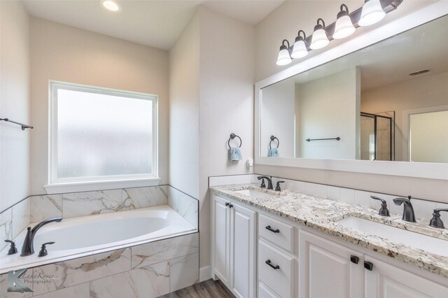 7309 Wildflower Way, Abilene, TX 79602 - bathroom with a bath, double vanity, a shower stall, wood finished floors, and recessed lighting