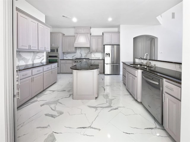 1832 Olney Dr, Allen, TX 75013 - kitchen featuring stainless steel appliances, dark countertops, arched walkways, backsplash, and a center island