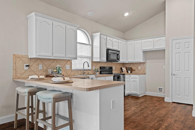 60 N Highland Dr, Sanger, TX 76266 - kitchen with black appliances, a peninsula, white cabinets, backsplash, and vaulted ceiling